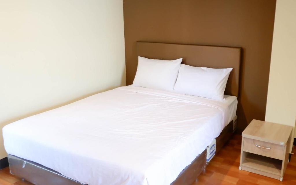 清迈Airport A1 Hotel的小客房内的一张床位,配有白色床单和枕头