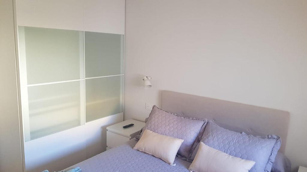 布尔戈斯Apartamento Vadillos - VuT 09-401的一间卧室配有一张带紫色床单和枕头的床。