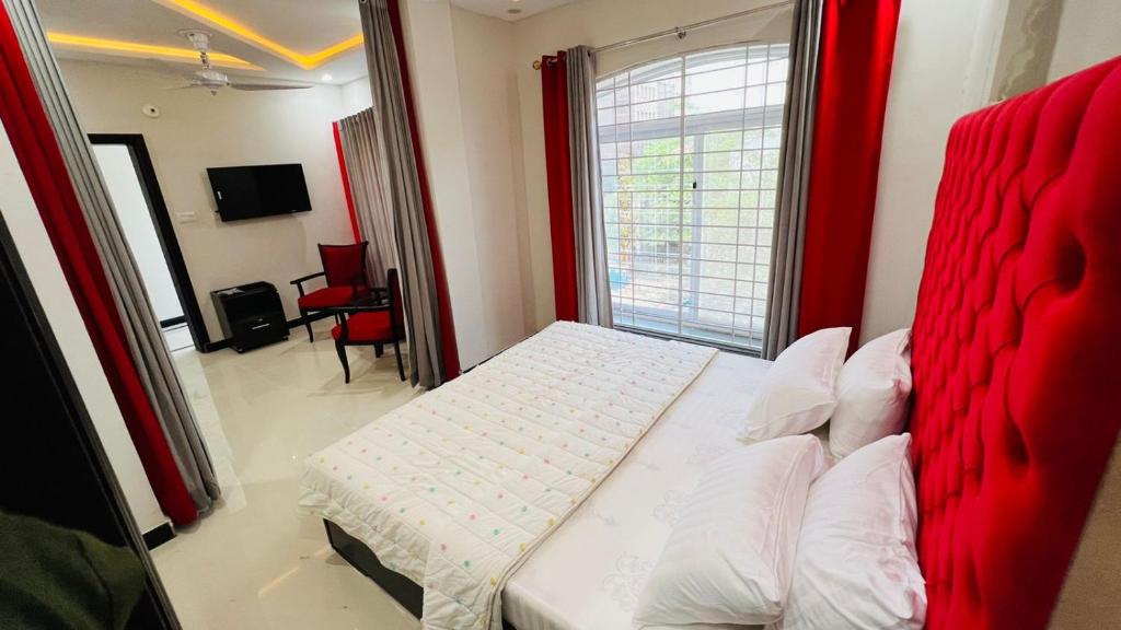 伊斯兰堡Hotel 11的一间卧室设有红色的床和窗户。