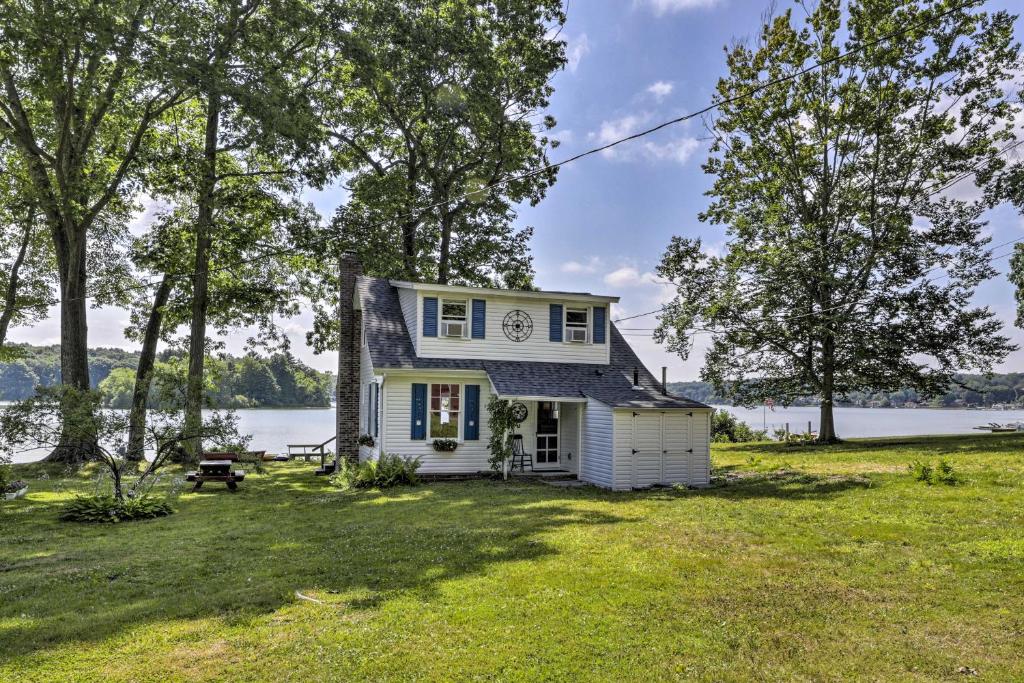 CoventryLakefront Cottage with Covered Porch and Dock!的一座位于草坪上的白色小房子,有湖泊