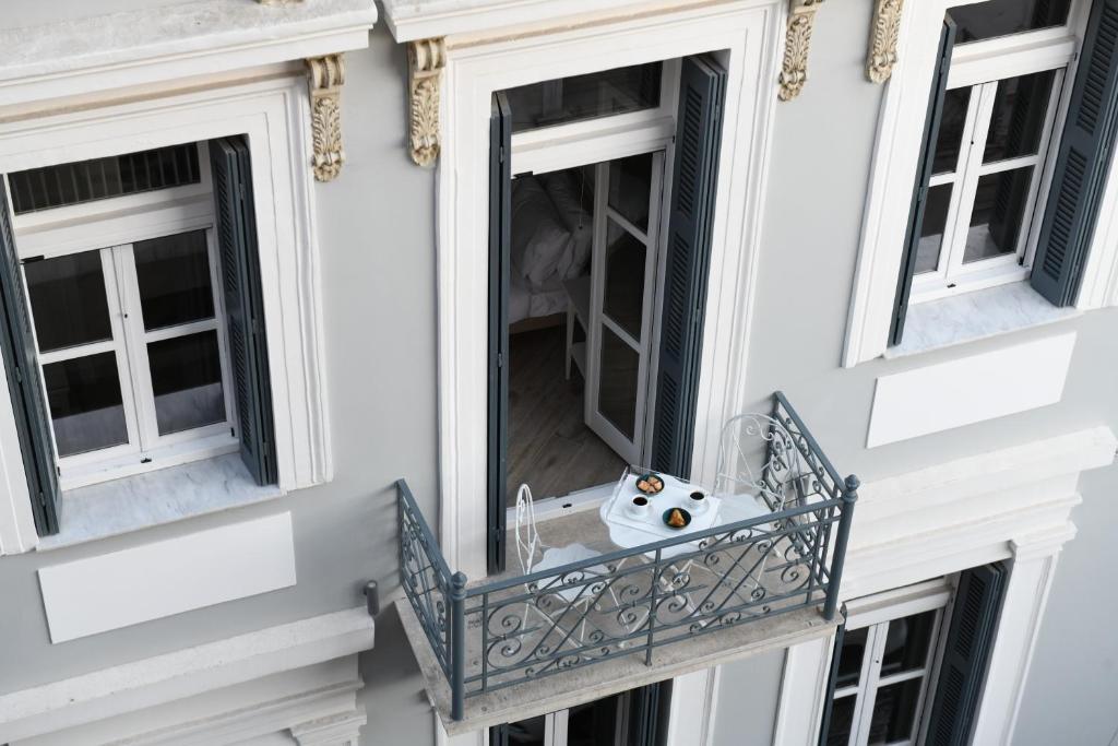 雅典Neapolis 1897 Boutique Luxury Rooms的一个带水槽的阳台和两个窗户
