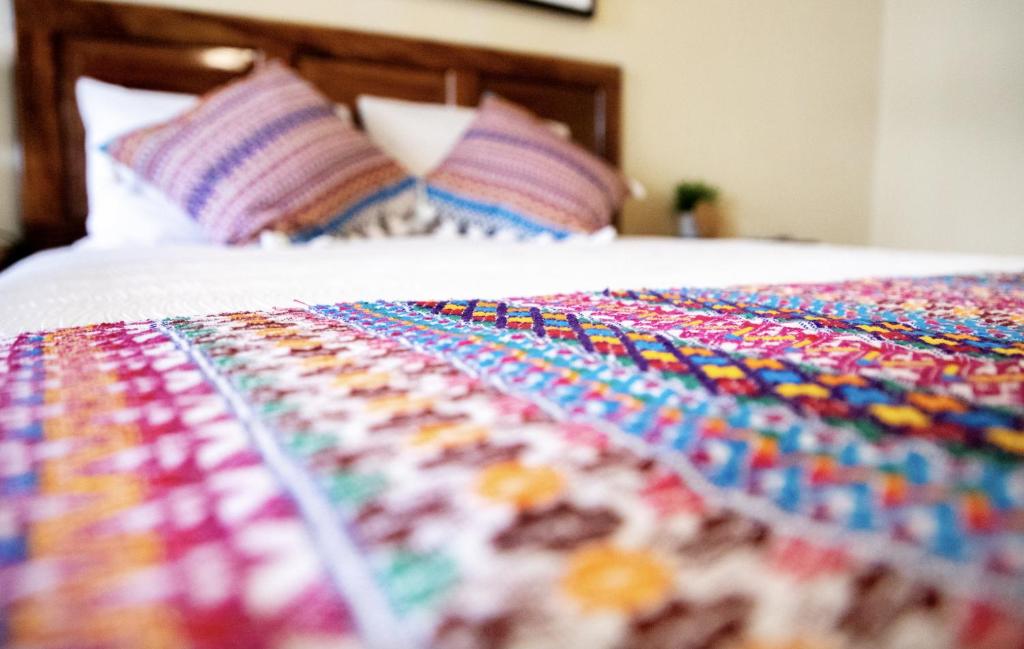 危地马拉安地瓜Nico Hotel的床上多彩的毯子,带枕头
