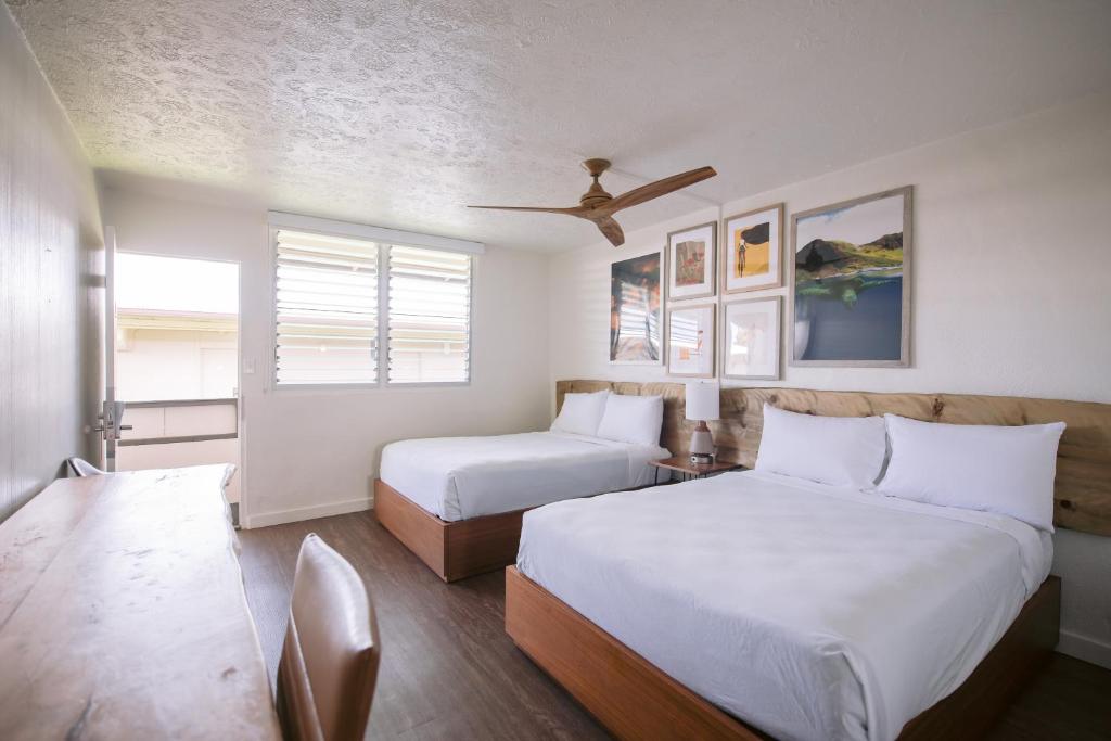 希洛SCP Hilo Hotel的一间卧室配有两张床和吊扇