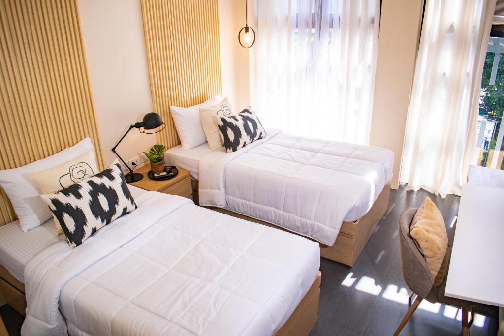 宿务D' Residences的一间卧室设有两张床和窗户。