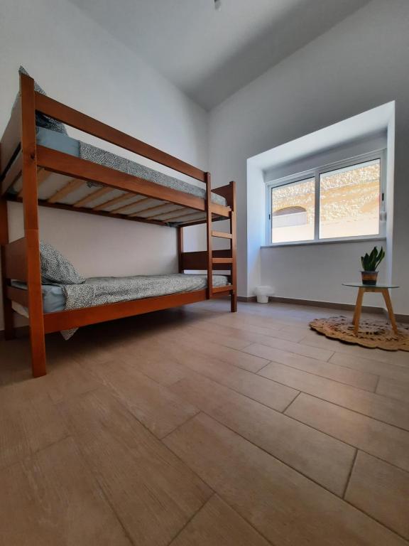 波尔蒂芒Blue Sardine Hostel的客房设有两张双层床,铺有木地板。