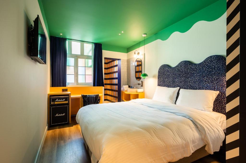 安特卫普P6 Antwerp的一间卧室设有一张带绿色天花板的大床