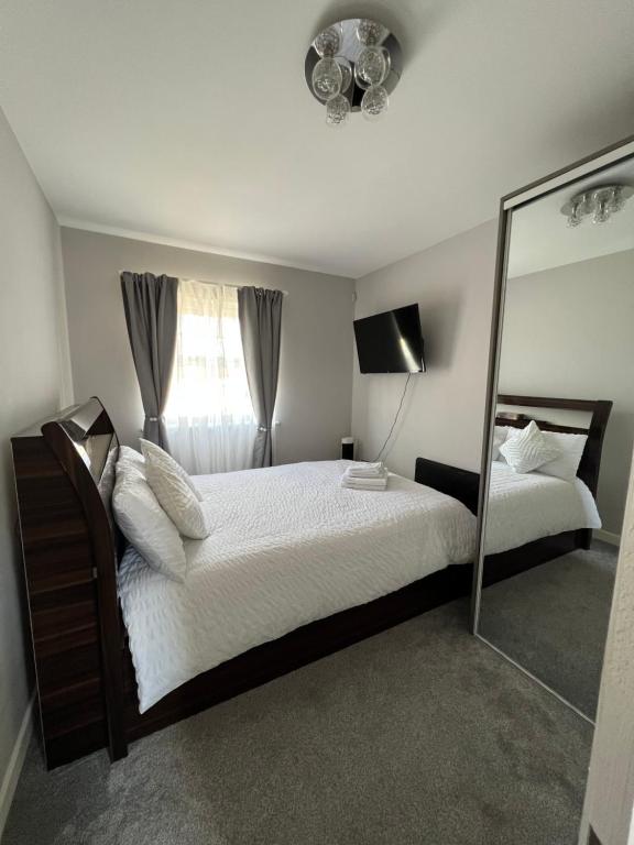 埃奇韦尔2 Double Bedroom Apartment in Edgware, London的一间卧室配有一张大床和镜子