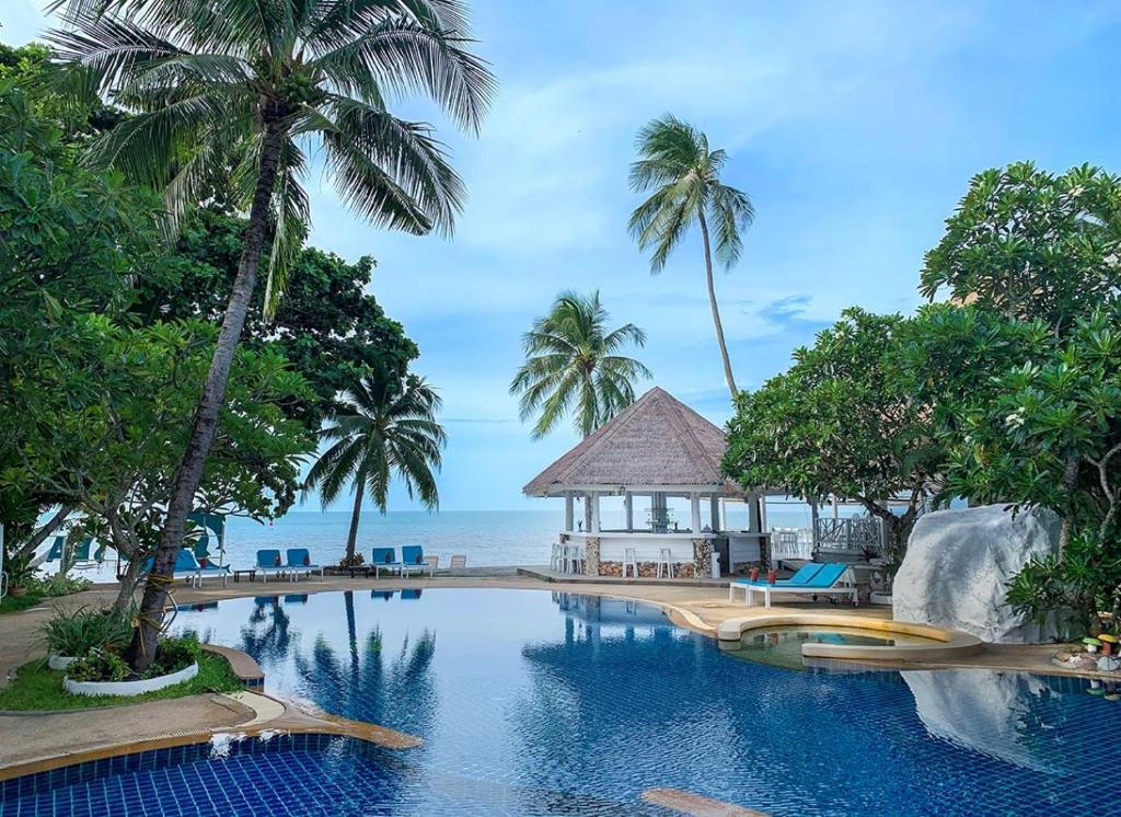 拉迈Sand Sea Beach Resort的棕榈树度假村的游泳池和凉亭