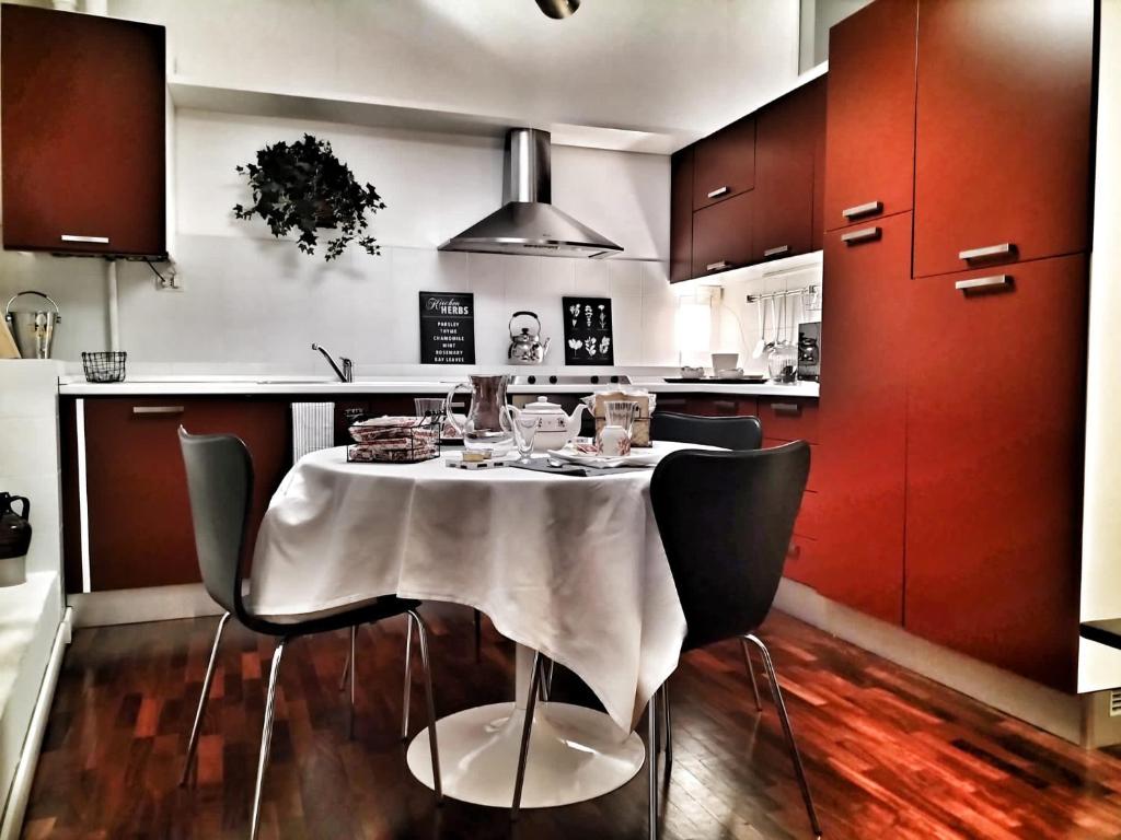 拉文纳Residenza Santi Muratori的厨房配有桌椅和红色橱柜