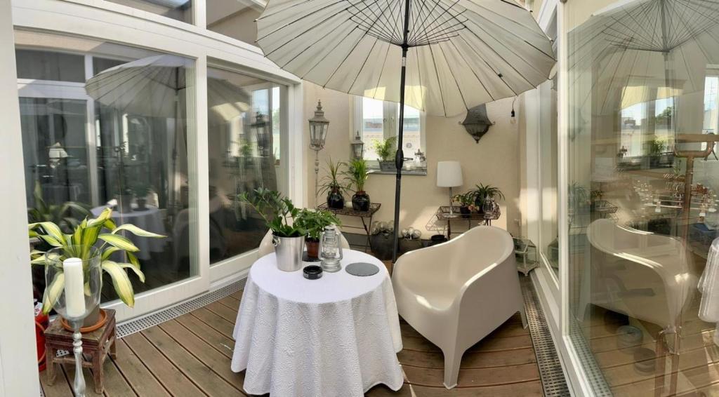 柏林Kreuzberger Szene Penthouse的一间带桌子和两把遮阳伞的用餐室