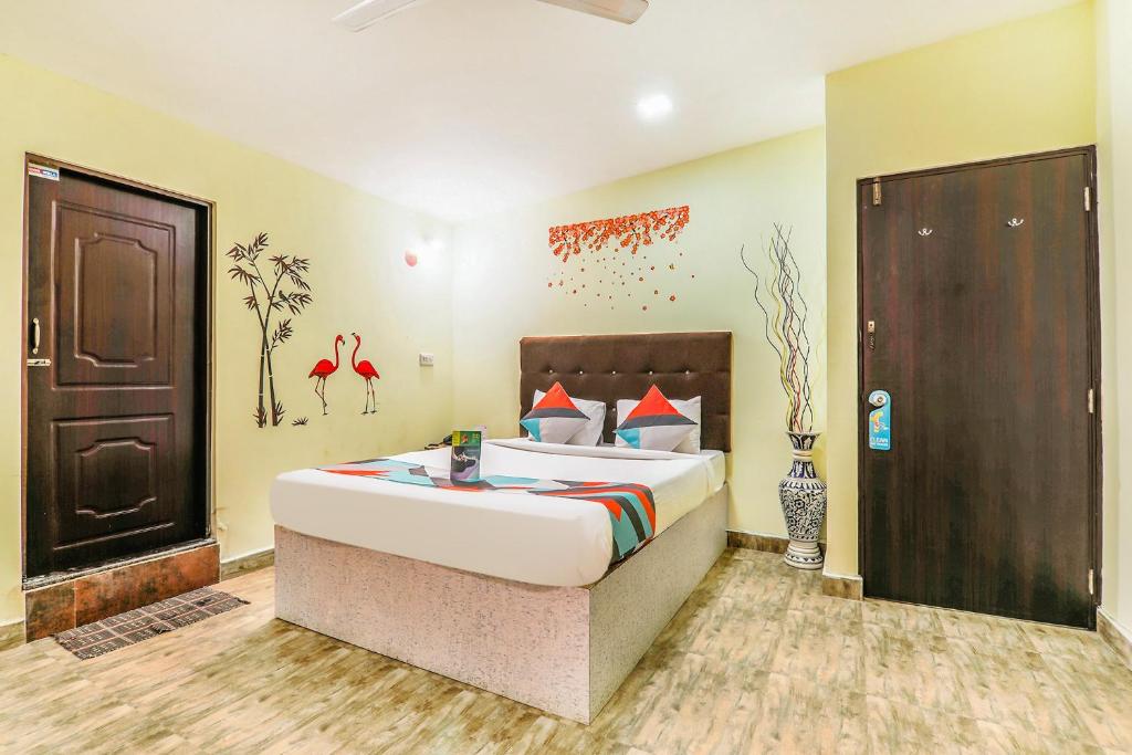 巴加FabExpress Victoria With Pool, Baga Beach的一间卧室设有一张大床和一扇棕色的门
