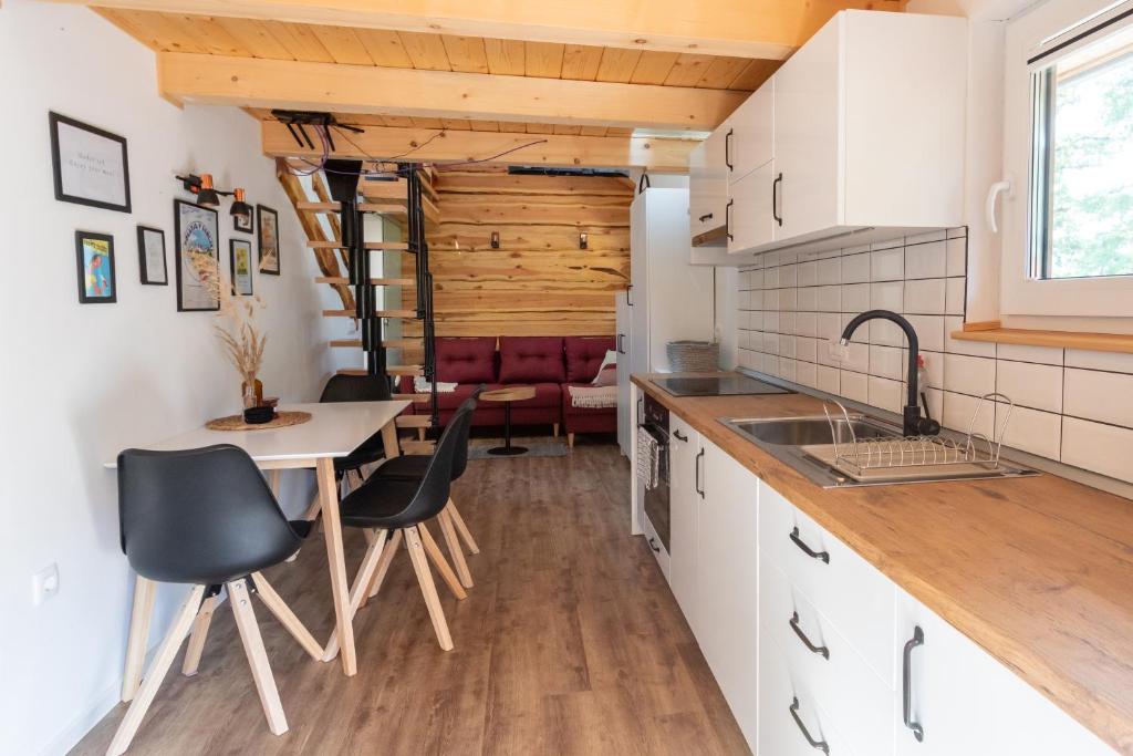 布莱德Lavender Lodge Bled的厨房配有白色橱柜和桌椅
