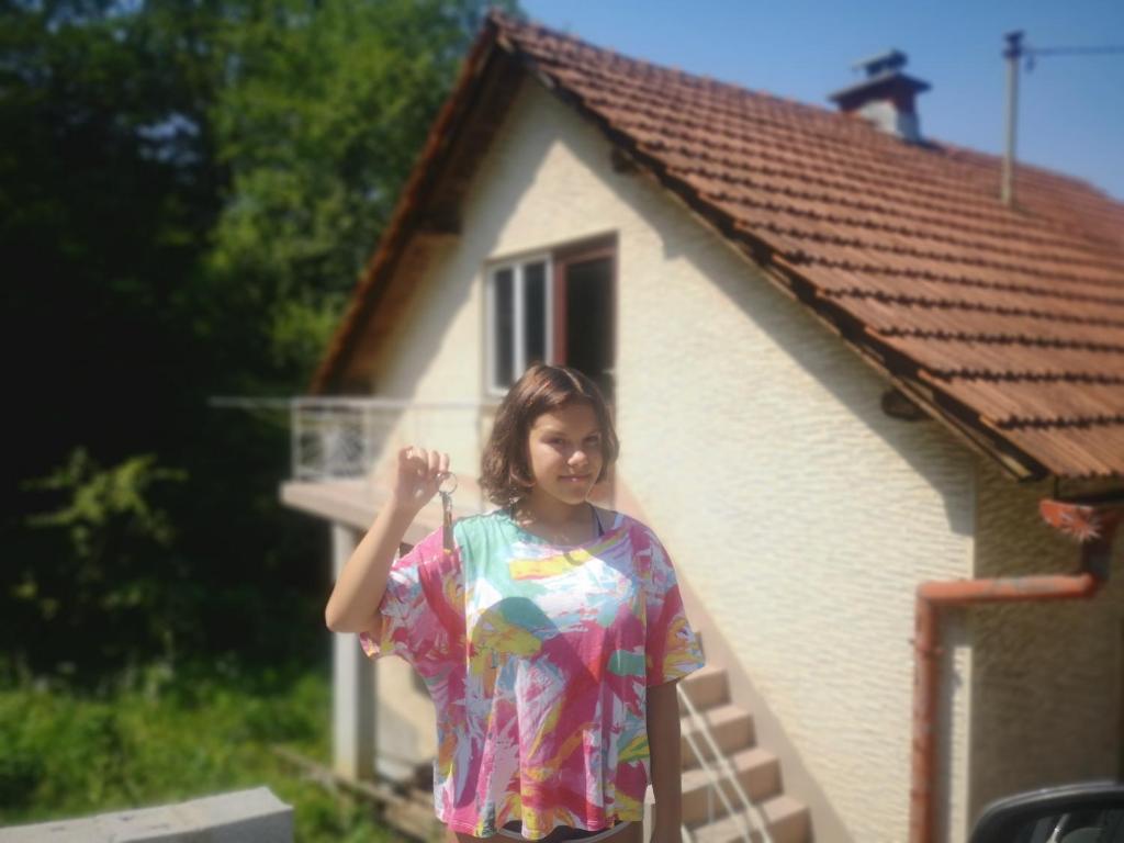 采列Small house in Celje的站在房子前面的女人