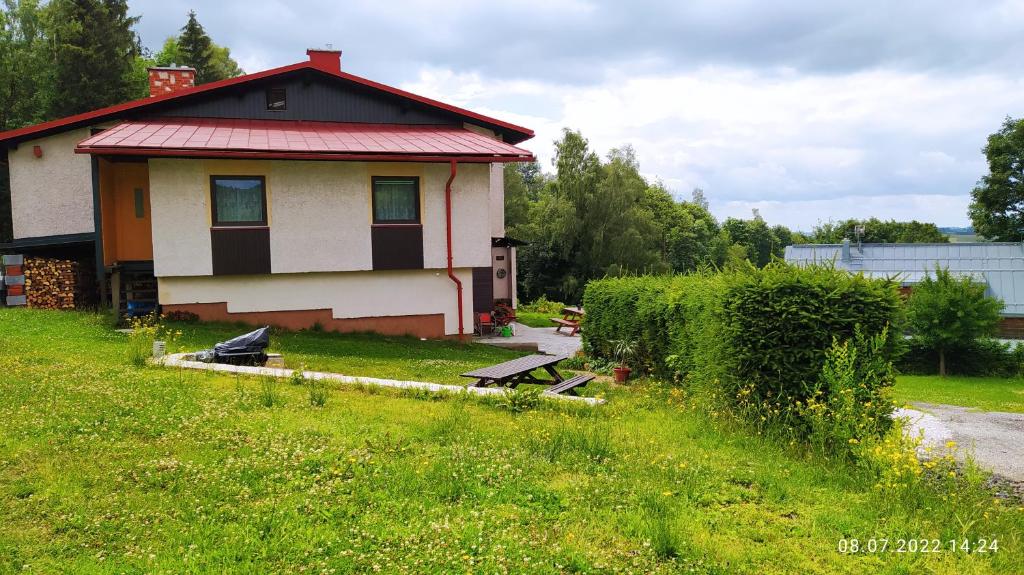 贝内茨科Apartmán Pod Žalým的田野上带红色屋顶的小房子