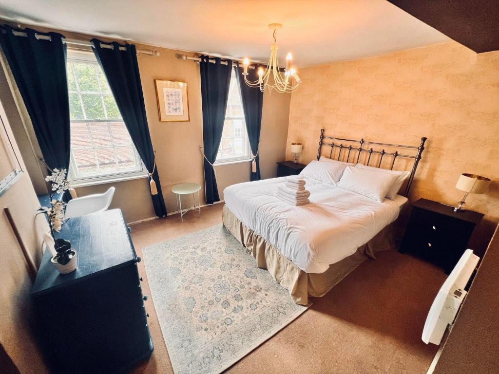BuckinghamshireGeorge & Dragon Hotel的一间卧室配有一张大床和一个吊灯。