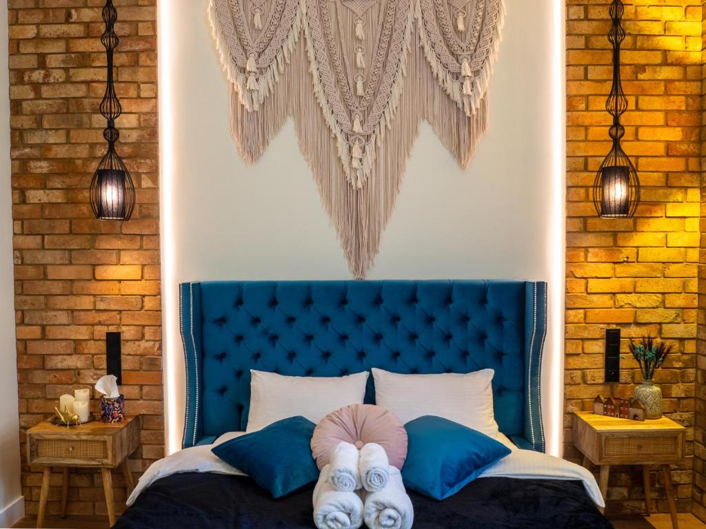 弗罗茨瓦夫Brick Castle - Apartament Ulrich的一间卧室配有一张蓝色的床,其中两人躺在床上