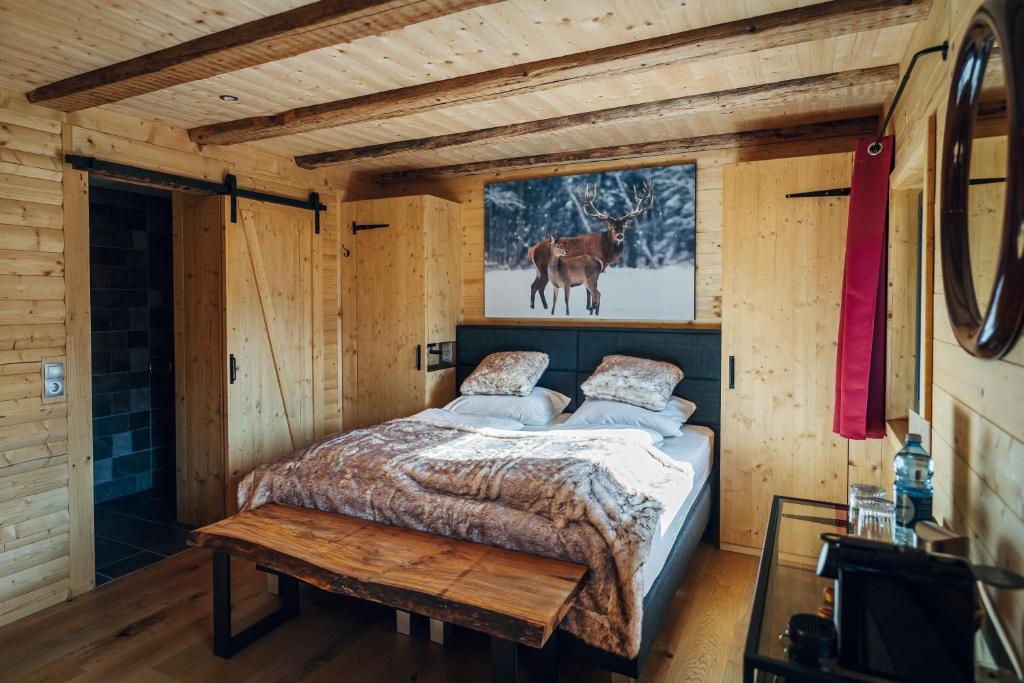 贝旺Alpen Lodge Berwang的小木屋内的卧室,配有一张床和一张桌子