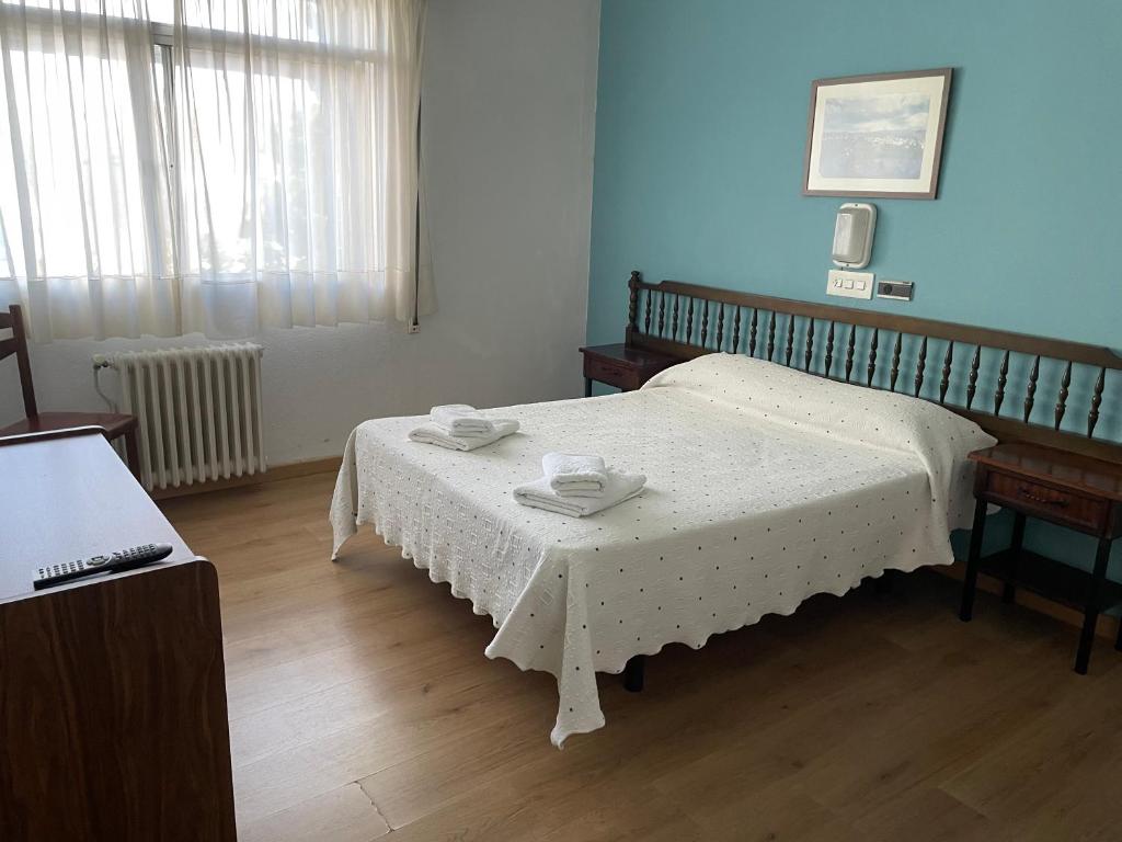 阿古迪尼亚Hotel relojero的一间卧室配有一张床和一张桌子,上面有两道菜