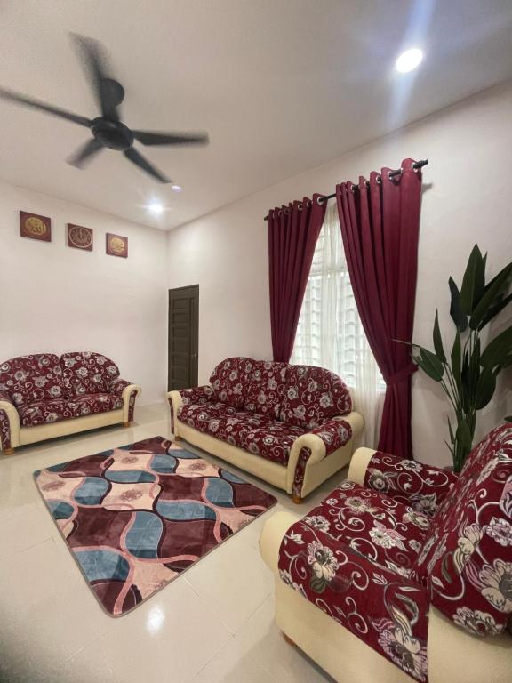 加央HOMESTAY BANDAR KANGAR (NS FAMILY HOMESTAY)的客厅配有两张沙发和地毯。