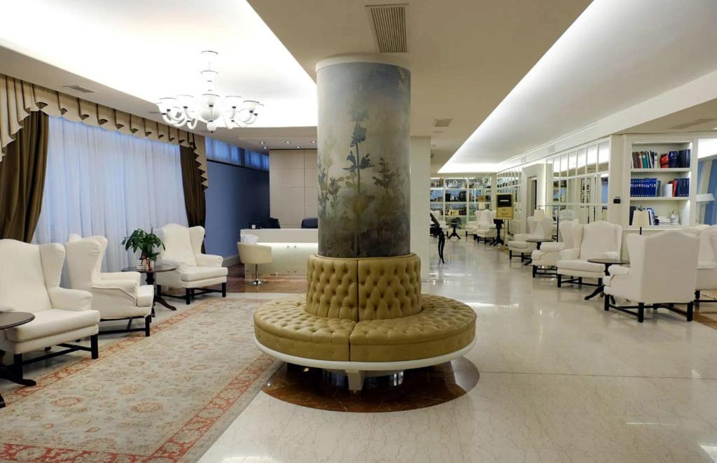 索阿韦罗克西广场酒店的中间设有白色椅子和柱子的大堂