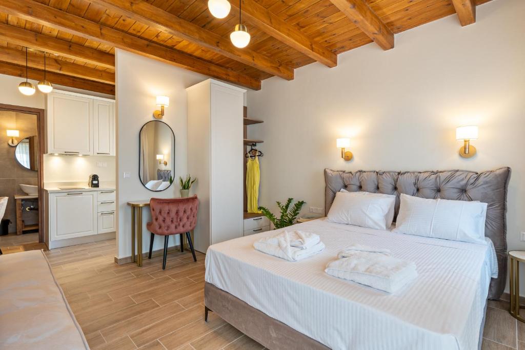 罗希姆诺Casa Del Balsamo的一间带白色大床的卧室和一间厨房