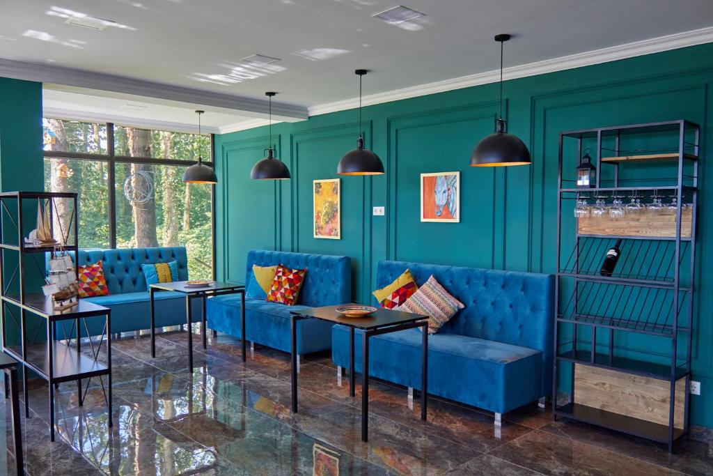 谢赫维蒂利Villa Story Hotel的客厅配有蓝色的家具和绿色的墙壁。