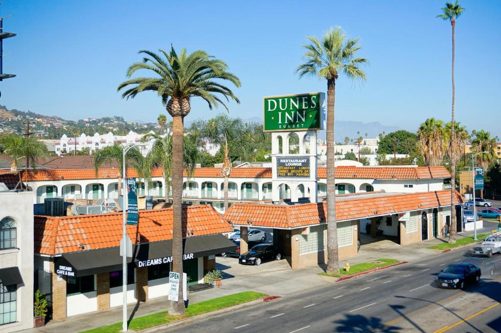 洛杉矶日落山丘酒店的棕榈树建筑前的街道标志