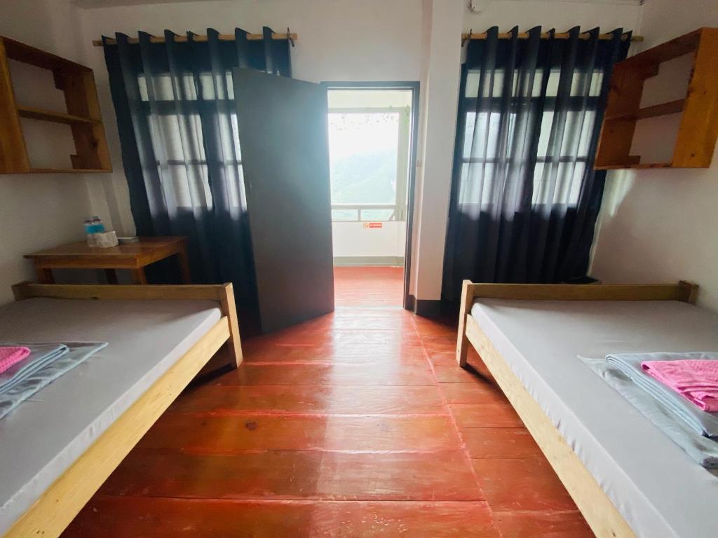 巴纳韦Batad Hillside Inn and Restaurant的带2张床的客房,位于带窗户的房间内