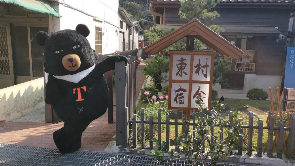 南庄乡南庄東村宿舍Nanzhuang Dongchon Homestay的一只大黑泰迪熊站在大门上