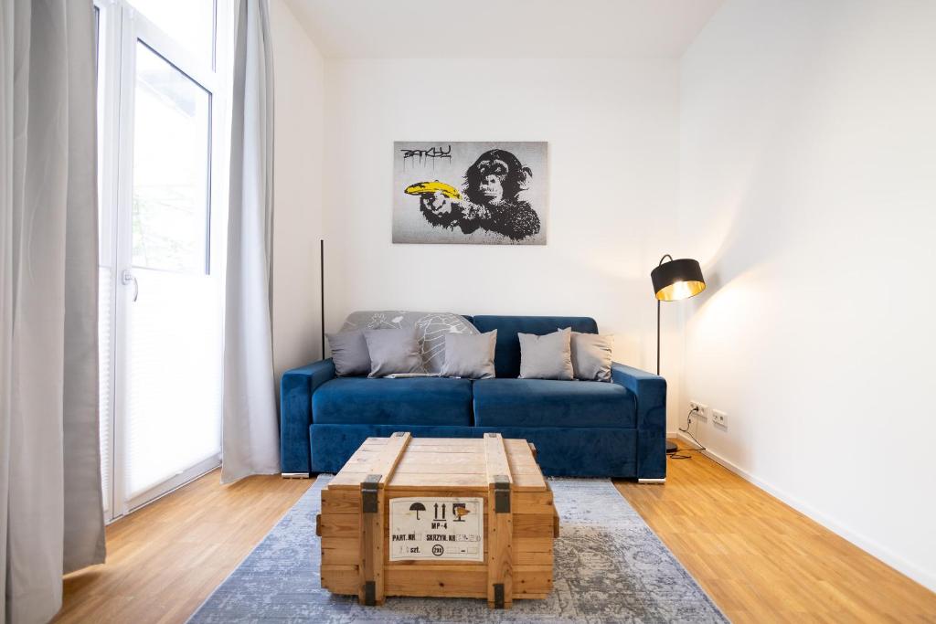 萨勒河畔哈雷Ko-Living - Beatles und Banksy Suites & Studios am Eselsbrunnen - Altstadt - Küche的客厅配有蓝色的沙发和茶几