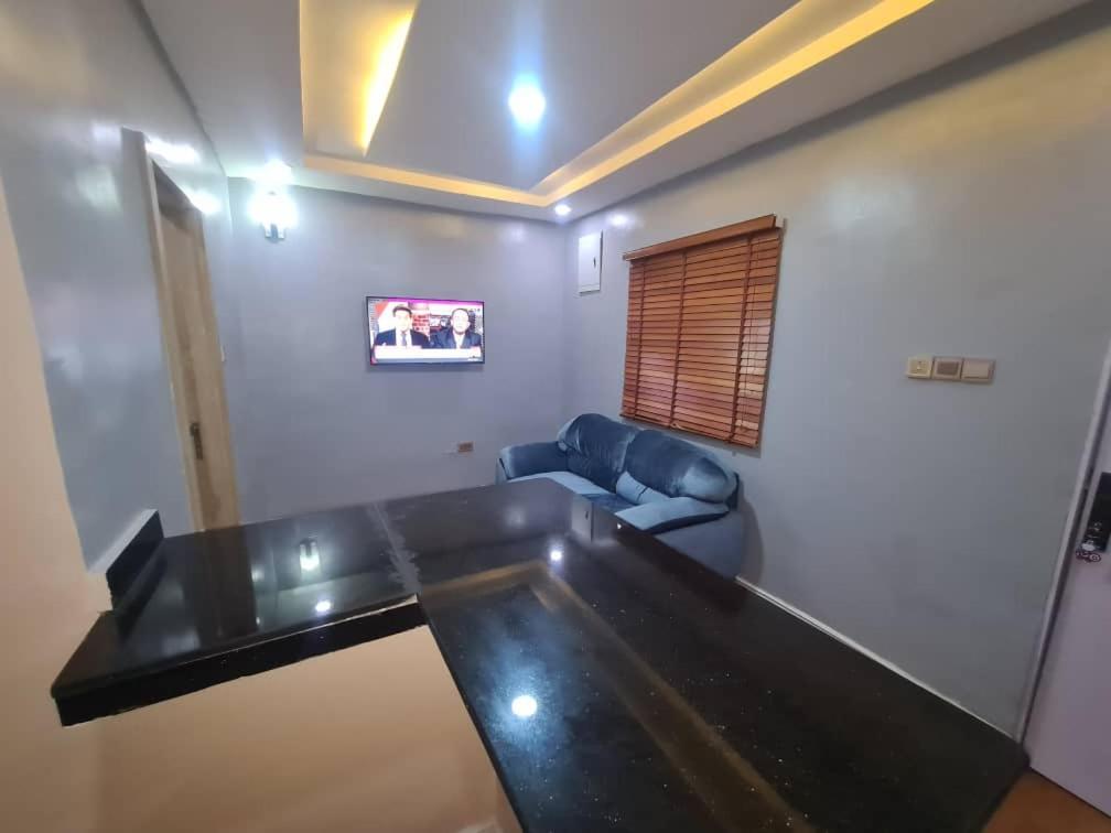 阿布贾Wine House, Maitama, Abuja的客厅配有桌子和沙发