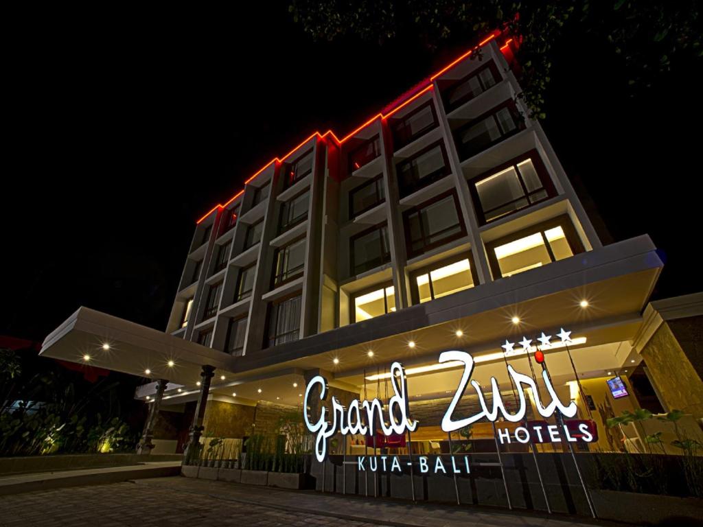 库塔巴厘库塔格兰德祖丽酒店的一家在晚上有标志的酒店