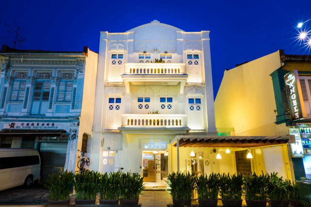新加坡The Daulat by Hotel Calmo的夜晚在城市里高大的白色建筑