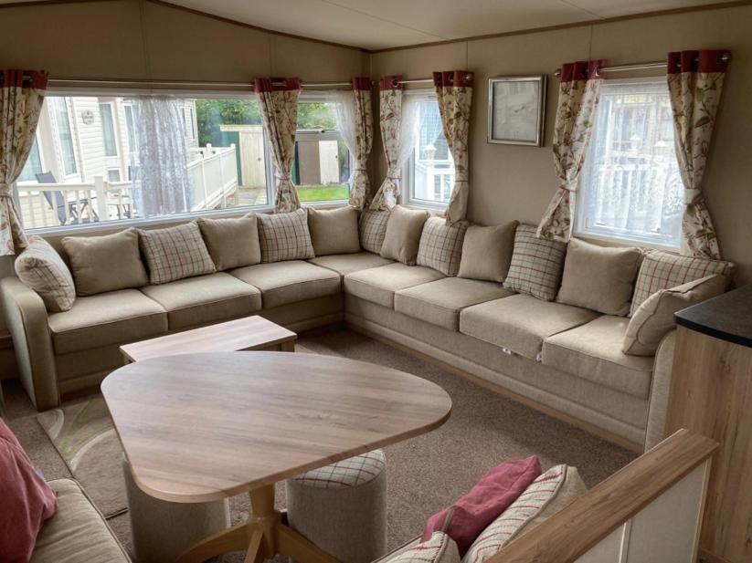 斯凯格内斯Deluxe 3 Bedroom Caravan with extra en-suite North Shore的客厅配有沙发和桌子