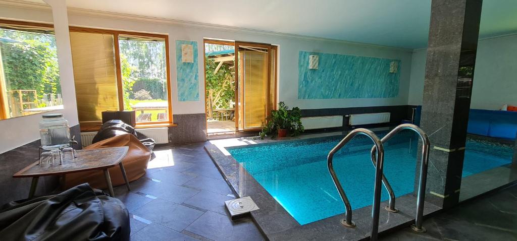 阿达兹Spacious house with indoor pool & sauna.的带沙发的房间内的大型游泳池