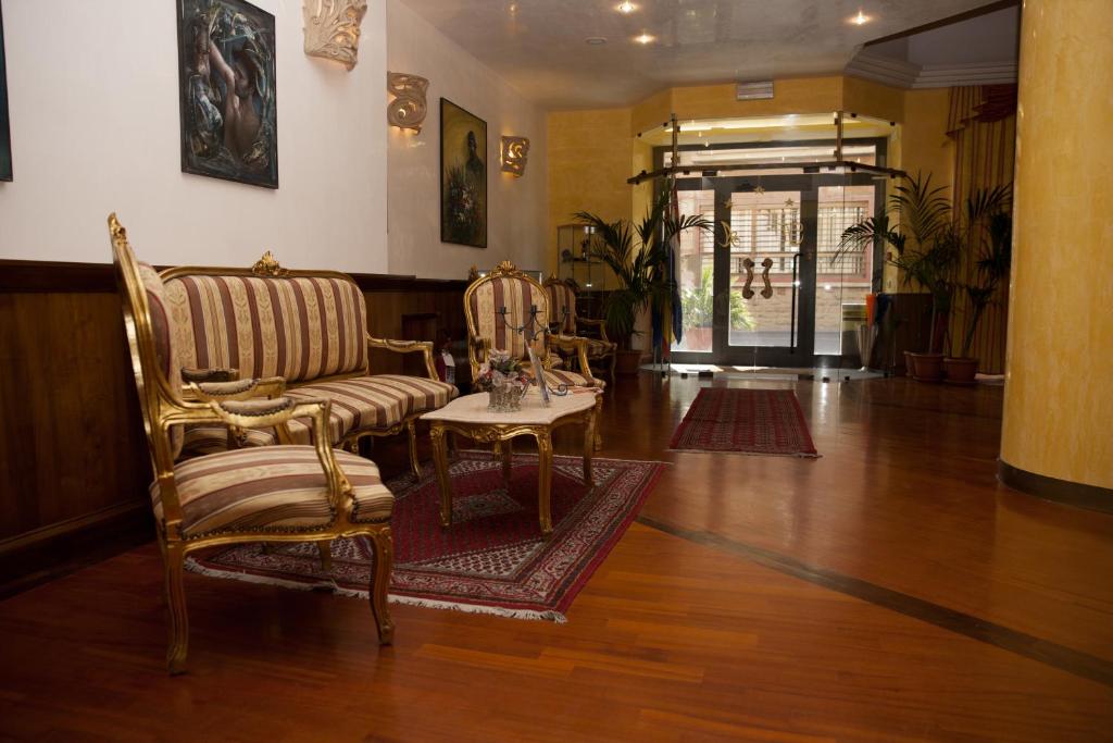 蒙蒂菲阿斯科尼阿尔塔维拉酒店的客厅配有两把椅子和一张桌子