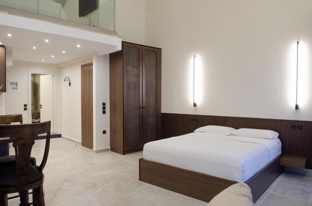 纳弗帕克托斯Leone suites的一间卧室配有一张床、一张桌子和一张桌子