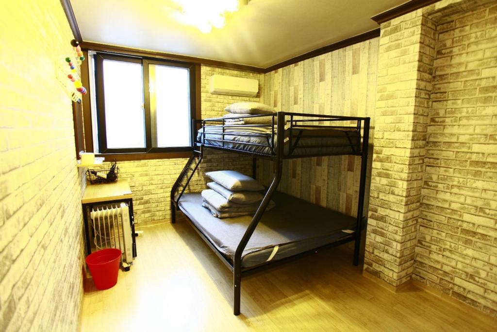 丹阳Jungle guesthouse的砖墙内的一个房间,配有双层床