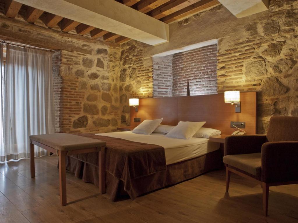 阿维拉拉斯莱耶恩达斯酒店的卧室配有一张石墙内的大床