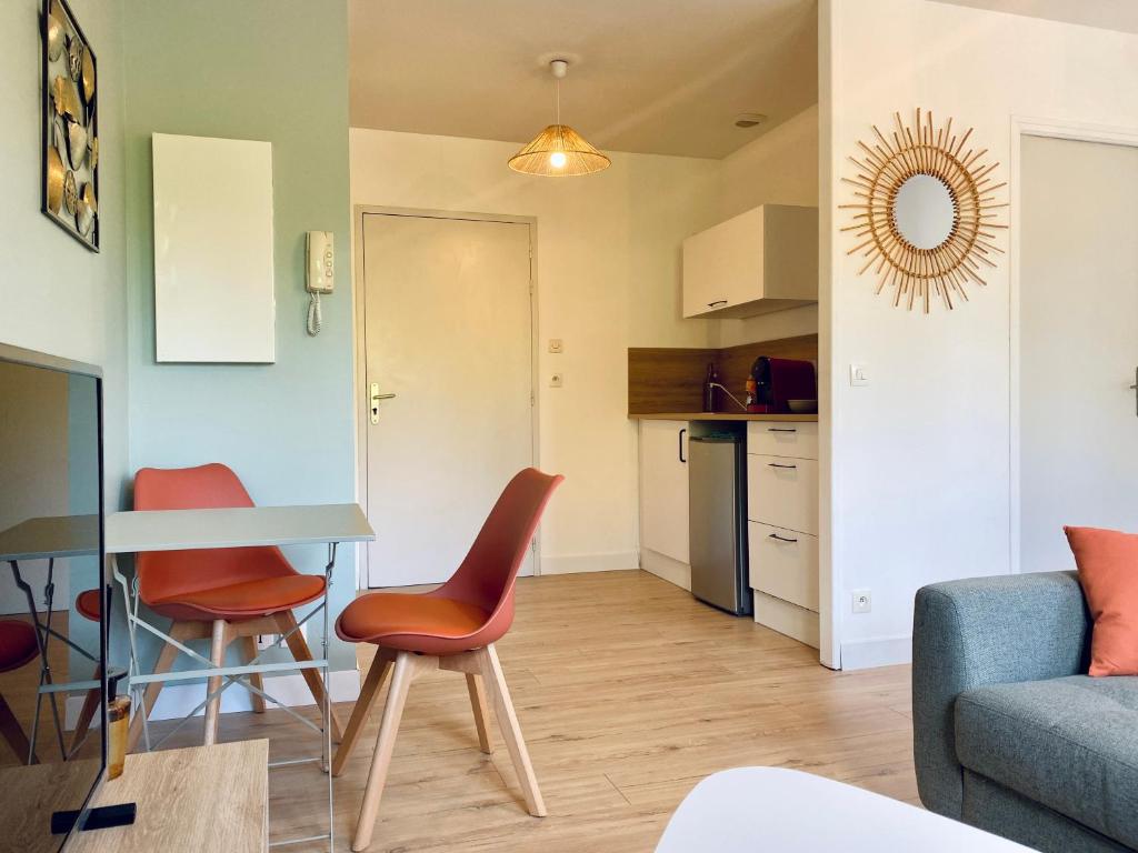 圣洛Appartement proche Hôpital et centre-ville的厨房以及带桌椅的起居室。