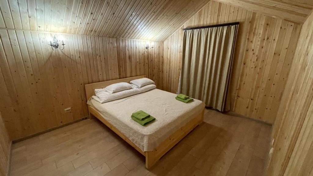 ShchuchinskiyOrman Ski的一间小卧室,配有一张位于木制房间内的床