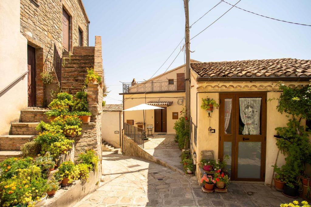 AlianoIl Paesaggio Lunare的种植盆栽的小巷和一座建筑