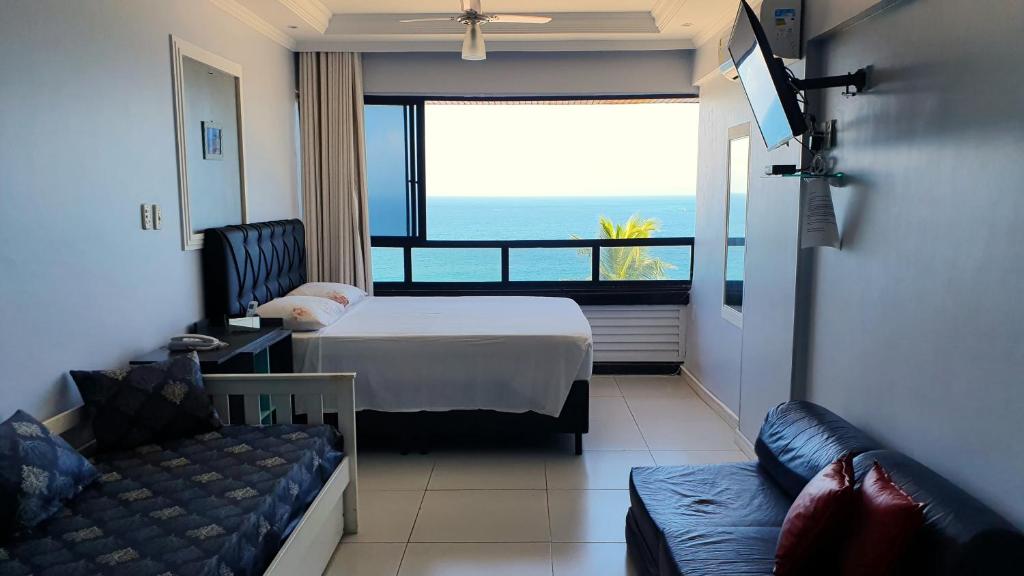 萨尔瓦多法罗尔巴拉公寓的酒店客房设有一张床,享有海景。