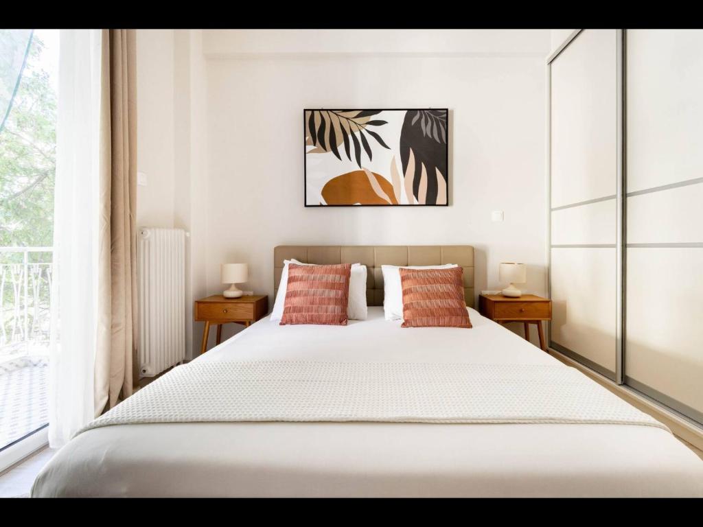 雅典Pagrati, Rizari的卧室配有带红色枕头的大型白色床