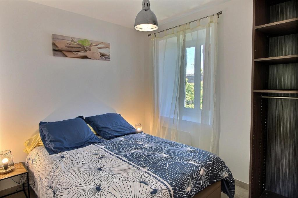 埃维昂莱班Apt type 3 en Duplex sur EVIAN les Bains vue lac的一间卧室配有一张带蓝色枕头的床和一扇窗户。