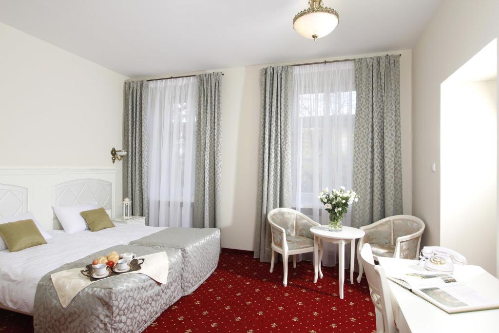 卢布林拉文多沃尔克度假村的酒店客房带一张床、一张桌子和椅子