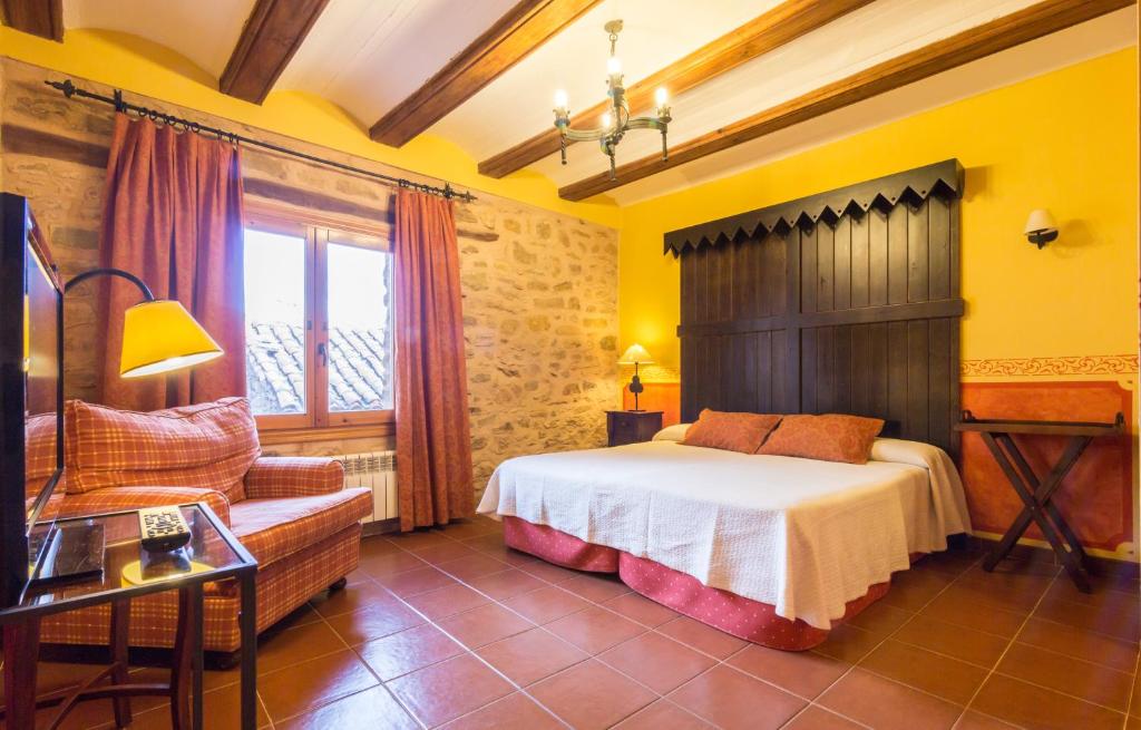 GalveCasa Rural La Yedra的卧室配有床、椅子和窗户。