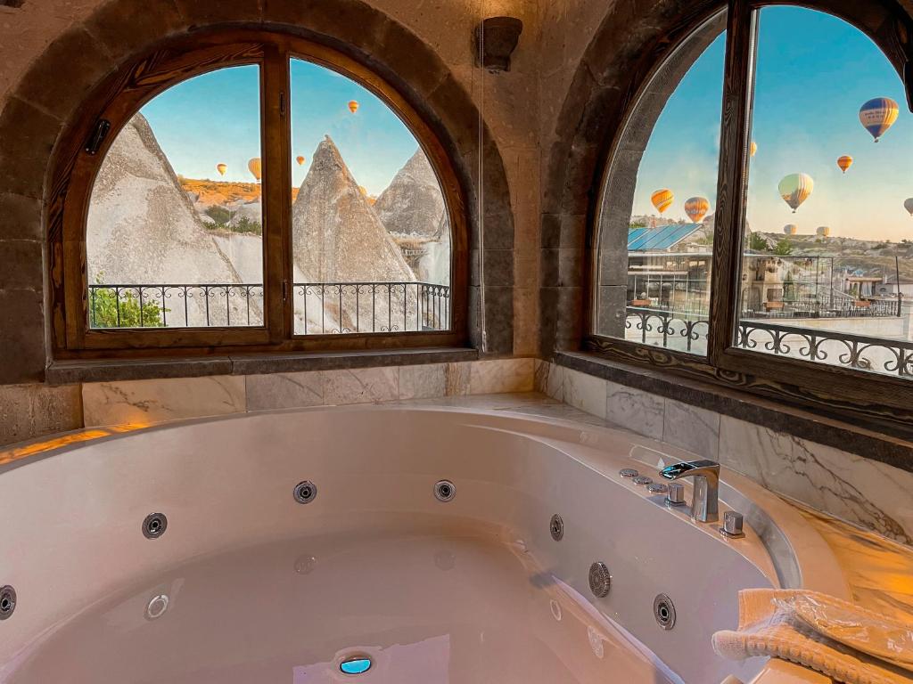 格雷梅格雷梅谷地洞穴居所酒店的带浴缸的三扇窗户