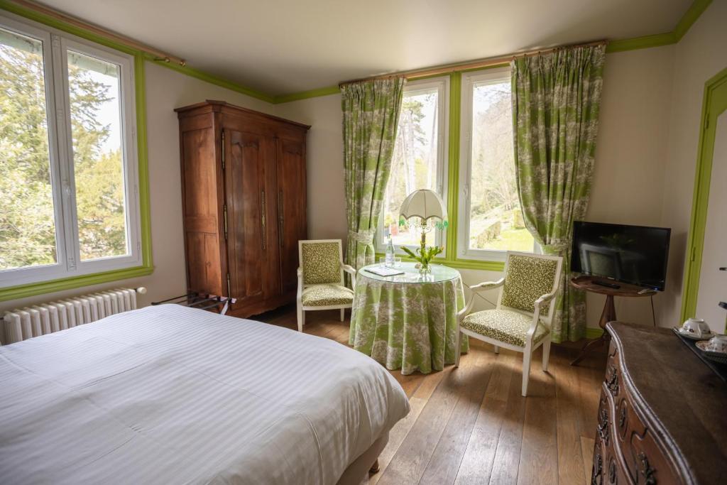 翁弗勒尔Le Manoir des Impressionnistes - Bord de Mer的卧室配有一张床和一张桌子及椅子