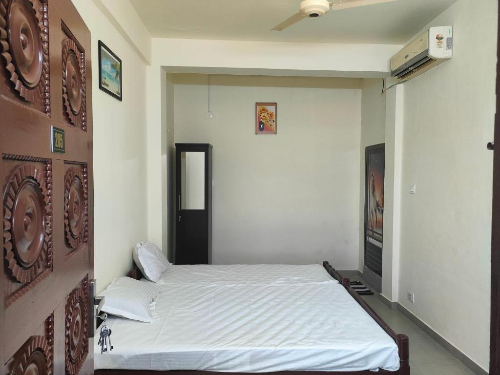 PonnāniJinnens Tourist Home的卧室配有白色的床